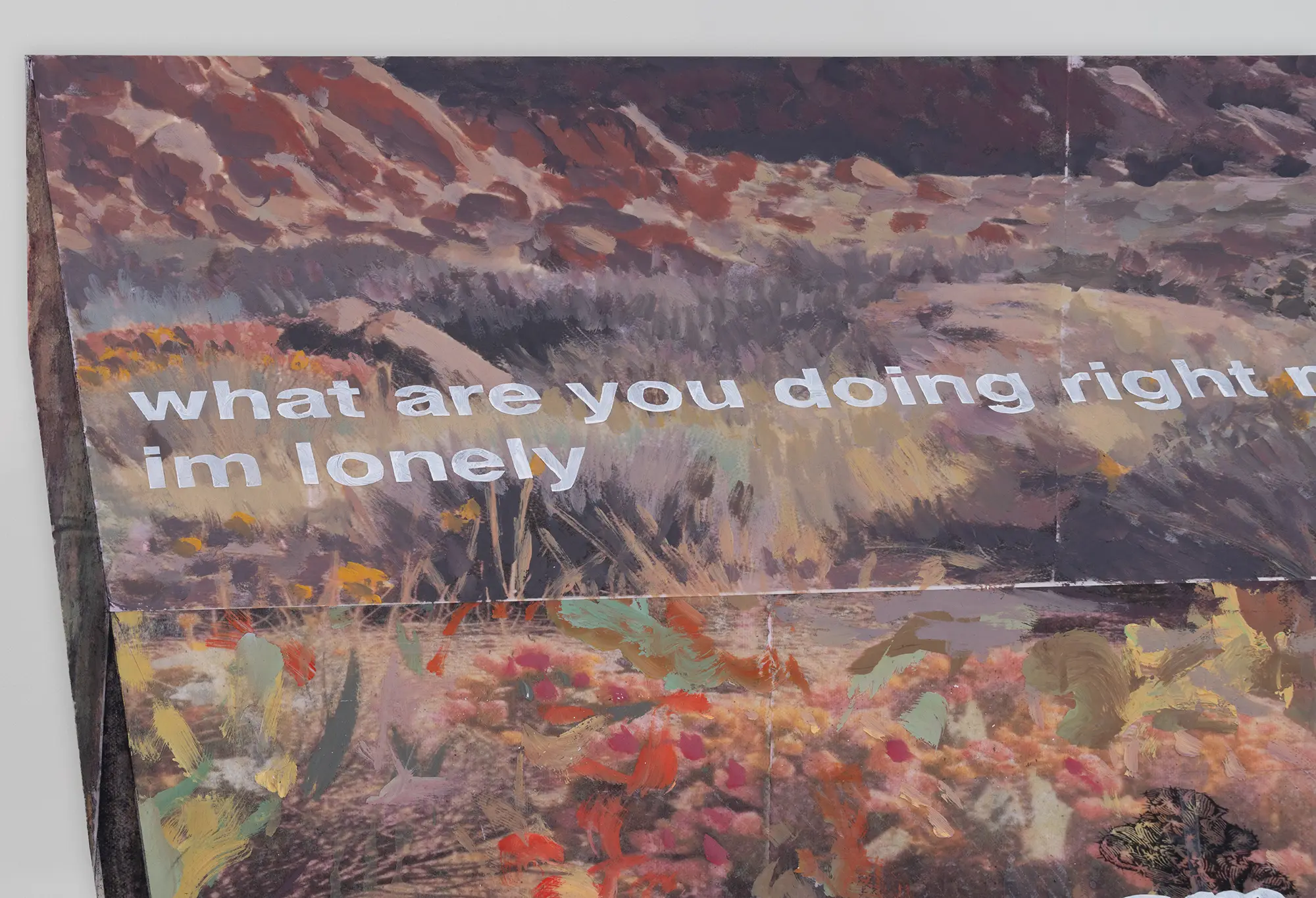 michael rikio ming hee ho detail of wall installation depicting a serene landscape with rugged hills and a meadow of wildflowers, overlaid with bold white text 'what are you doing right now, im lonely' contrasting against the natural background