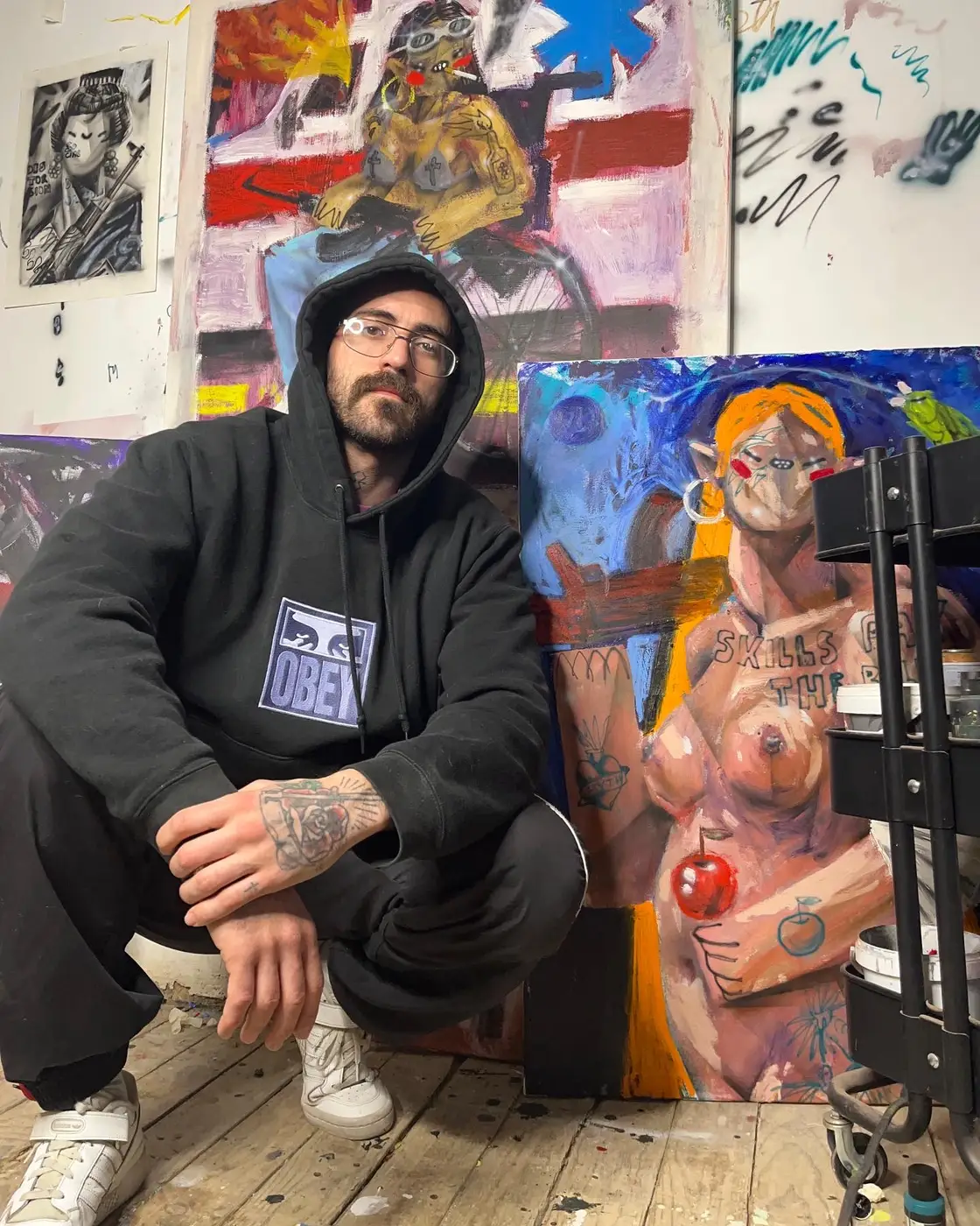 alvar mena, spanish artist in his studio with paintings, image courtesy of the artist 2024