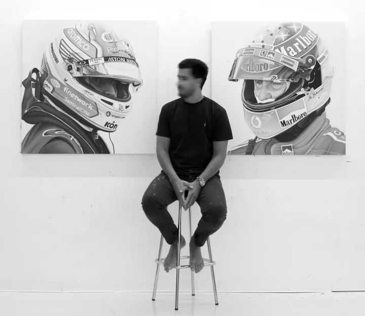 ricardo rodriguez cosme sitting in front of his formula one themed paintings figurative painting now munchies art cl